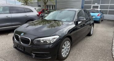 BMW mit Schweizer Kennzeichen und Fahrzeugausweis auf Motorhaube – erfolgreicher Verkauf in der Schweiz